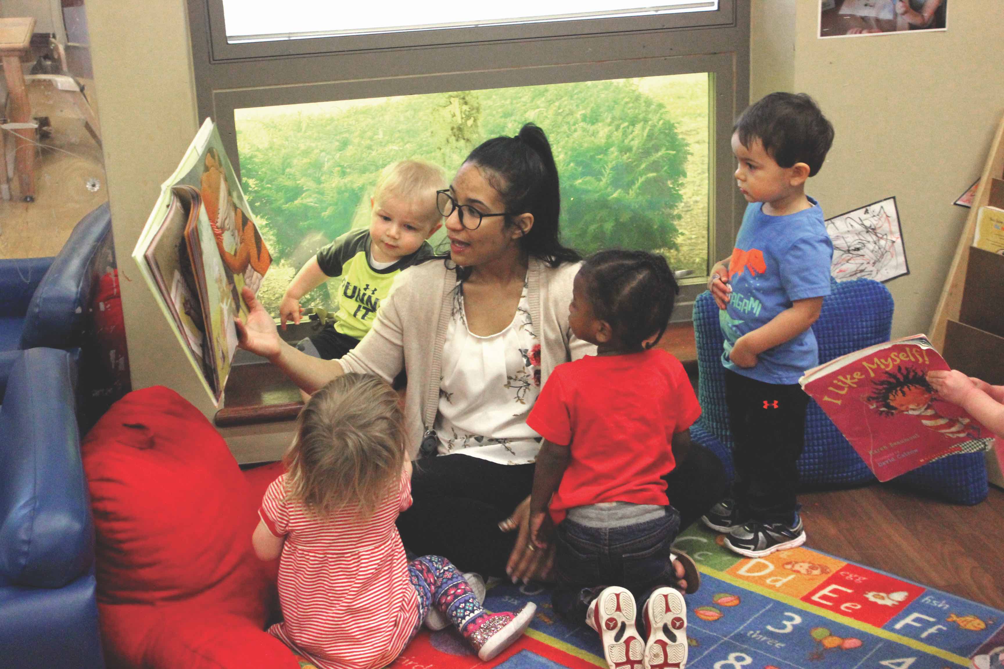 Teacher reading a picture book to young students in a classroom