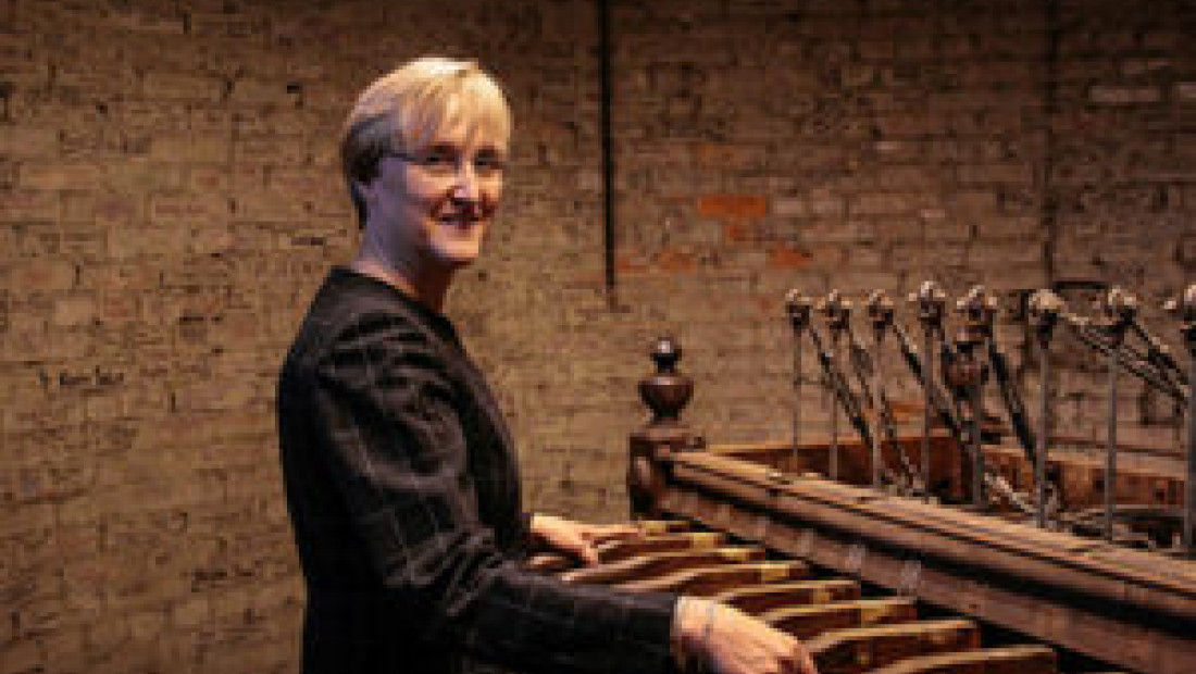 Cathy Montalto standing in front of a bells musical instruments