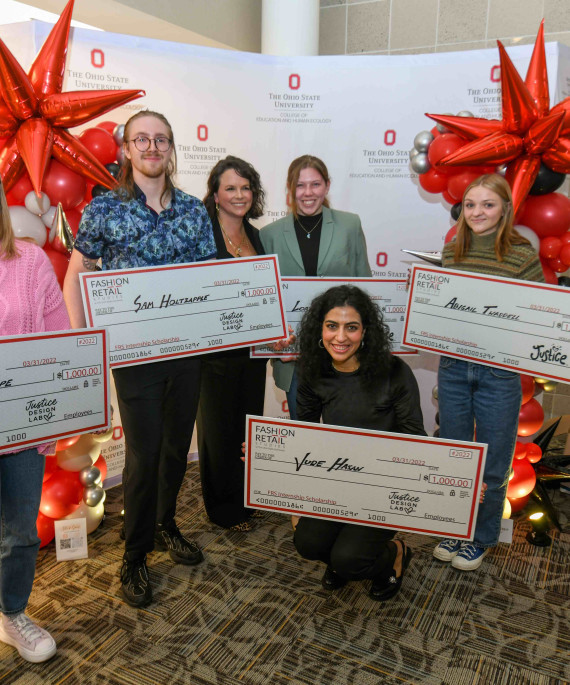 Ohio State students holding large checks at scholarship celebration