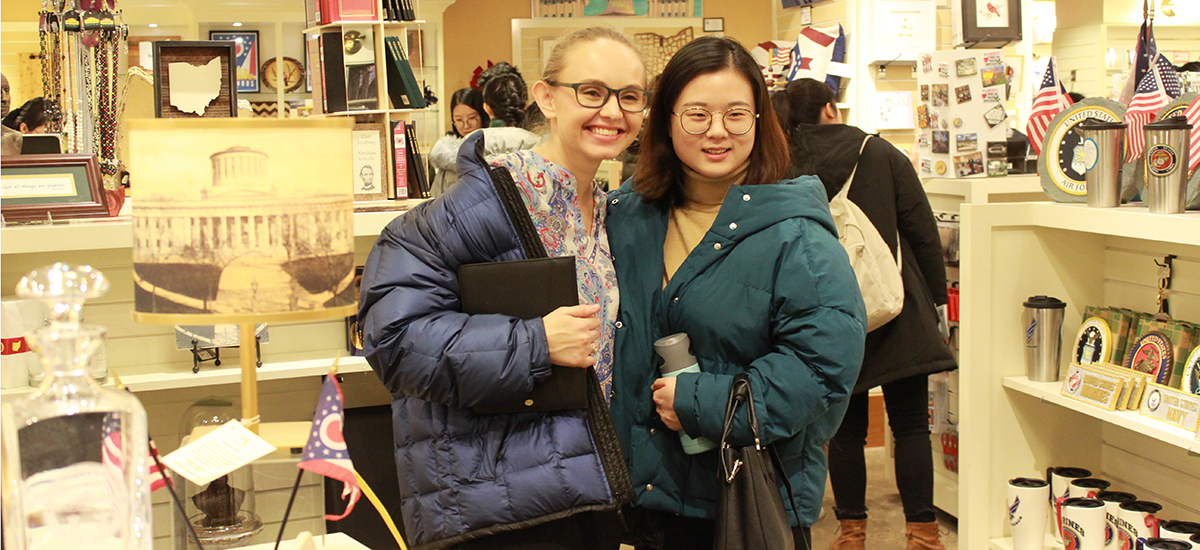 Communications intern Nicole Hopwood and student Shuhui Zhao befriend each other while shopping at the State House.
