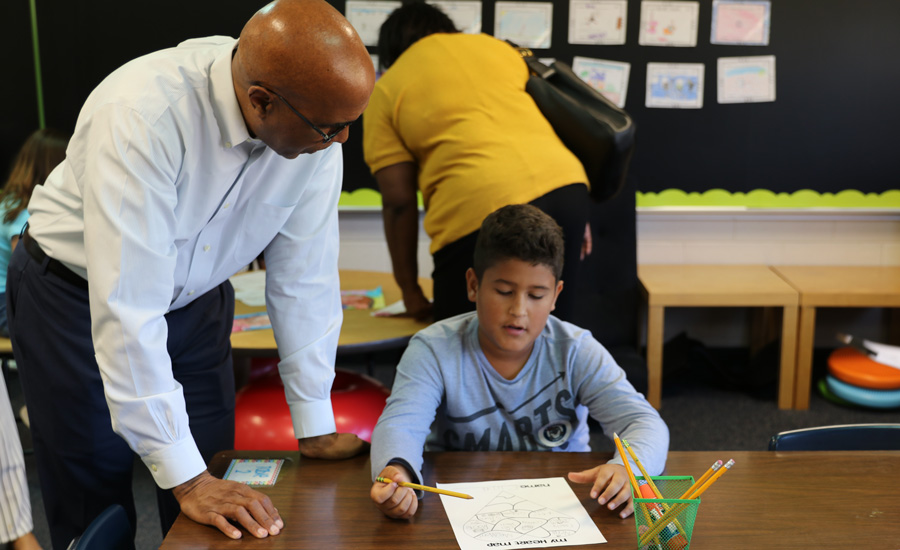 College dean meets with local school student at table