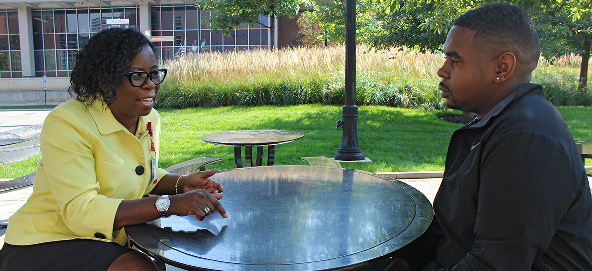 Alumni Award winner Shelly Martin sits at a table with her former employee Taurean Washington.