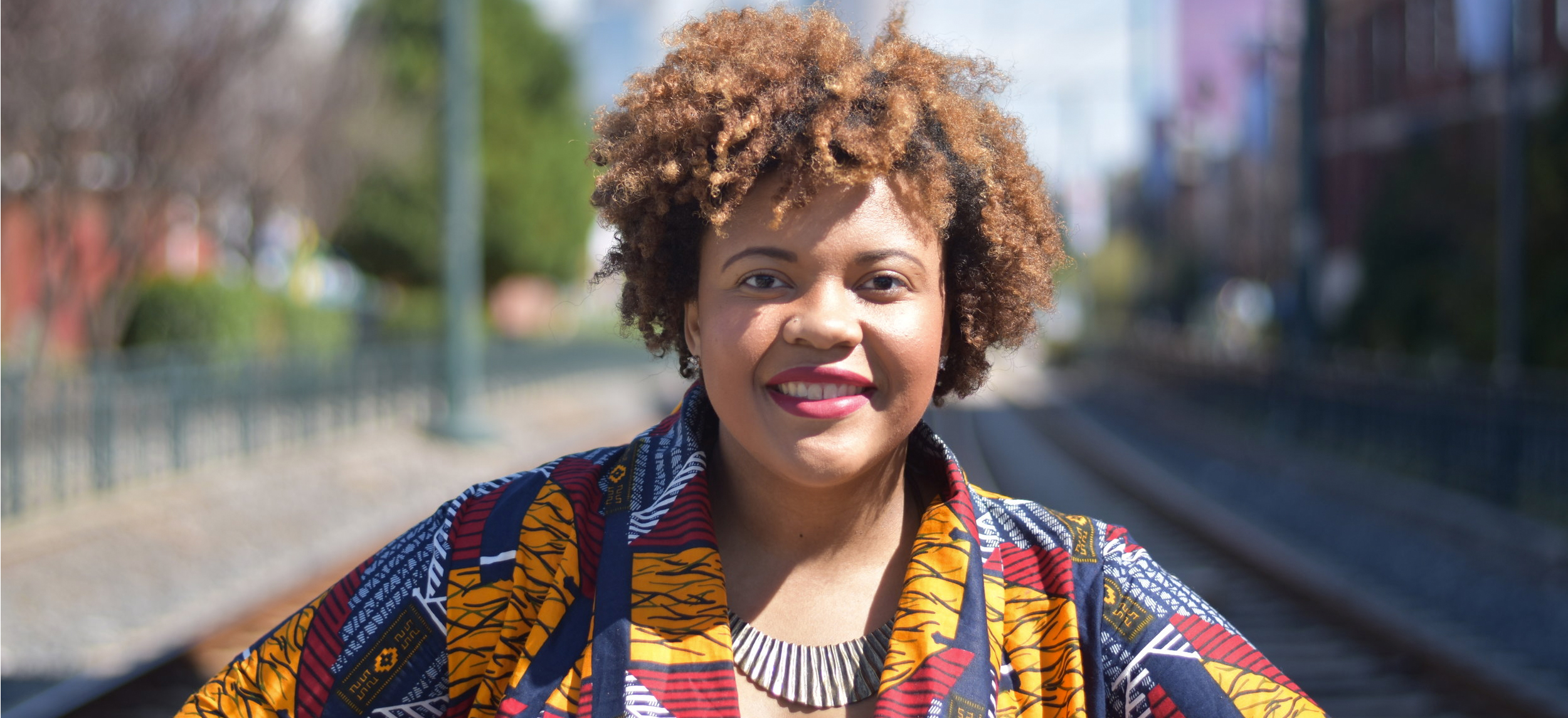 Alumna Erica Jordan Thomas stands on train tracks in Charlotte, North Carolina, where she worked as a principal.