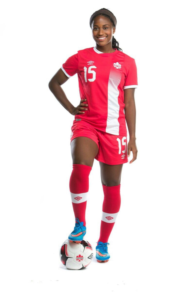 Canadian soccer player stands with right foot on soccer ball