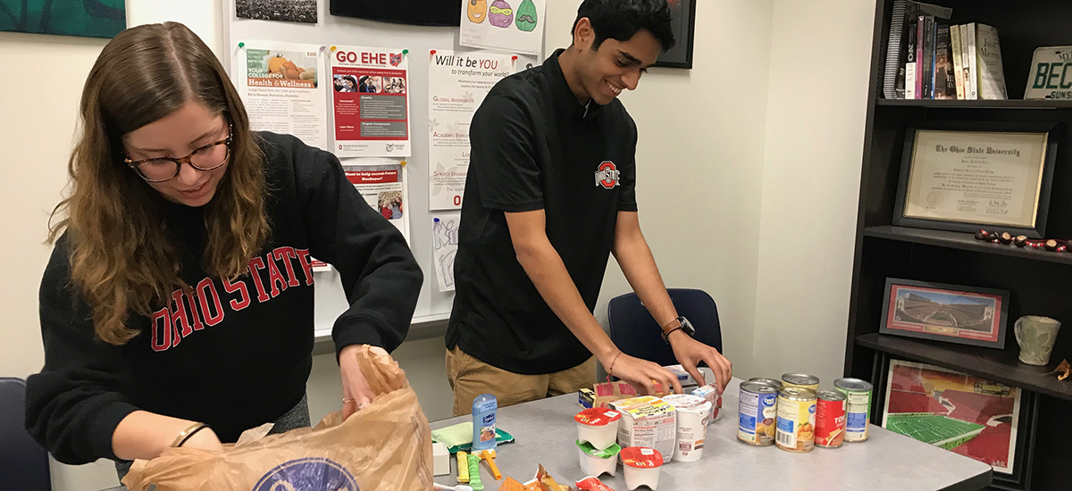 Braylee Gaertner, left, and Aditya Mistry sort food items for the College of Education of Human Ecology food pantry.