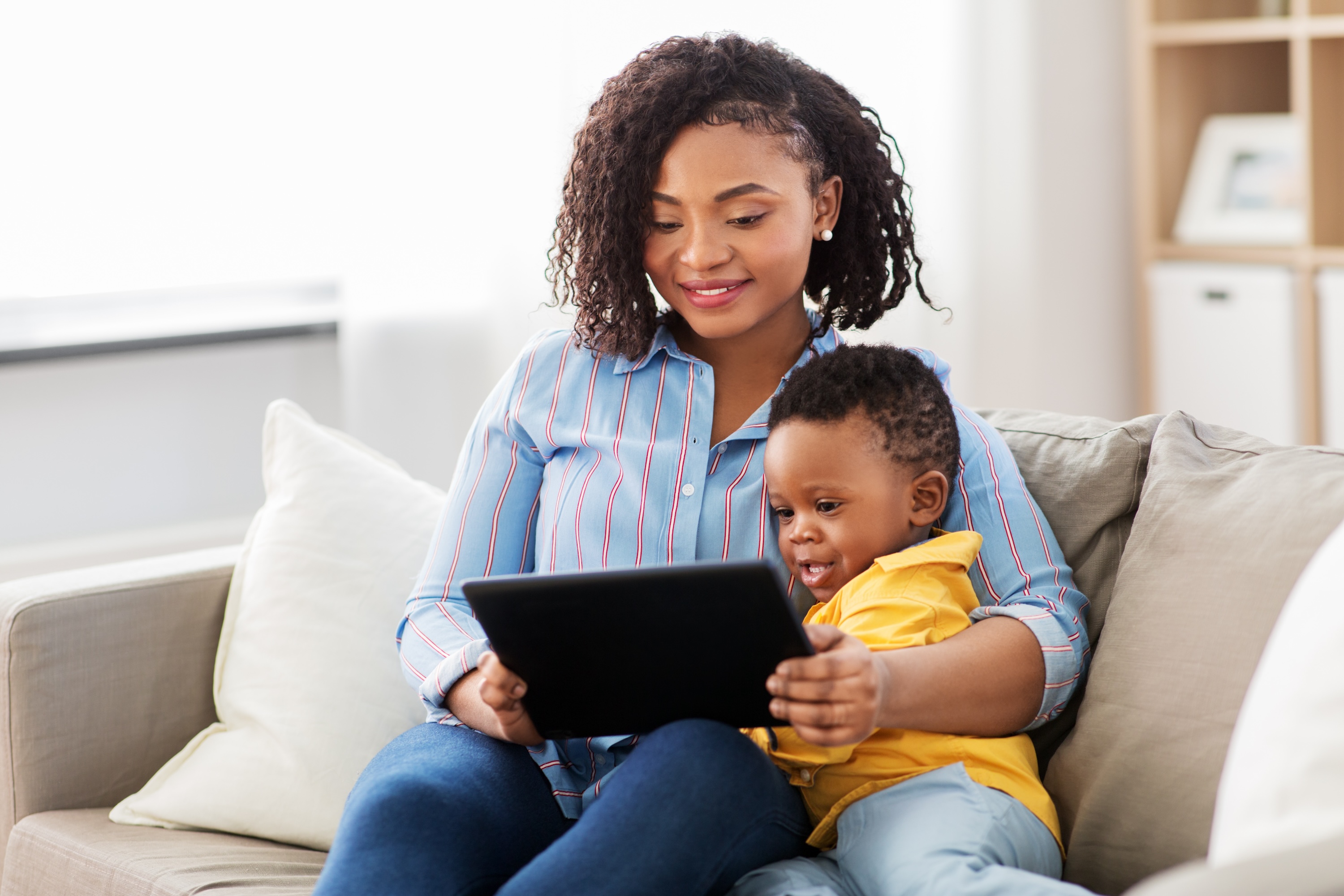 mother sitting with child looking at tablet