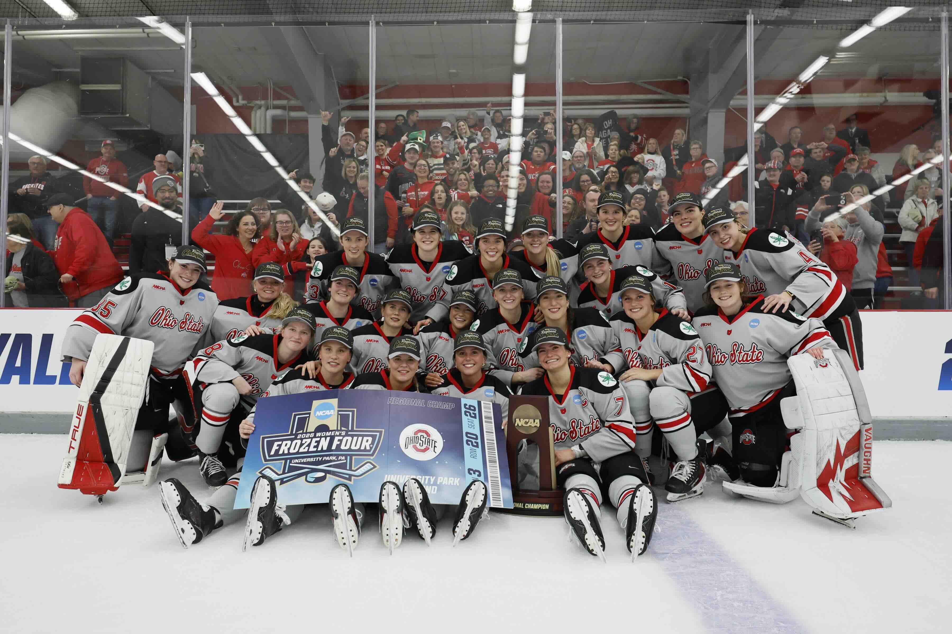 Ohio State women's hockey team together on the ice holding a sign for the Frozen Four