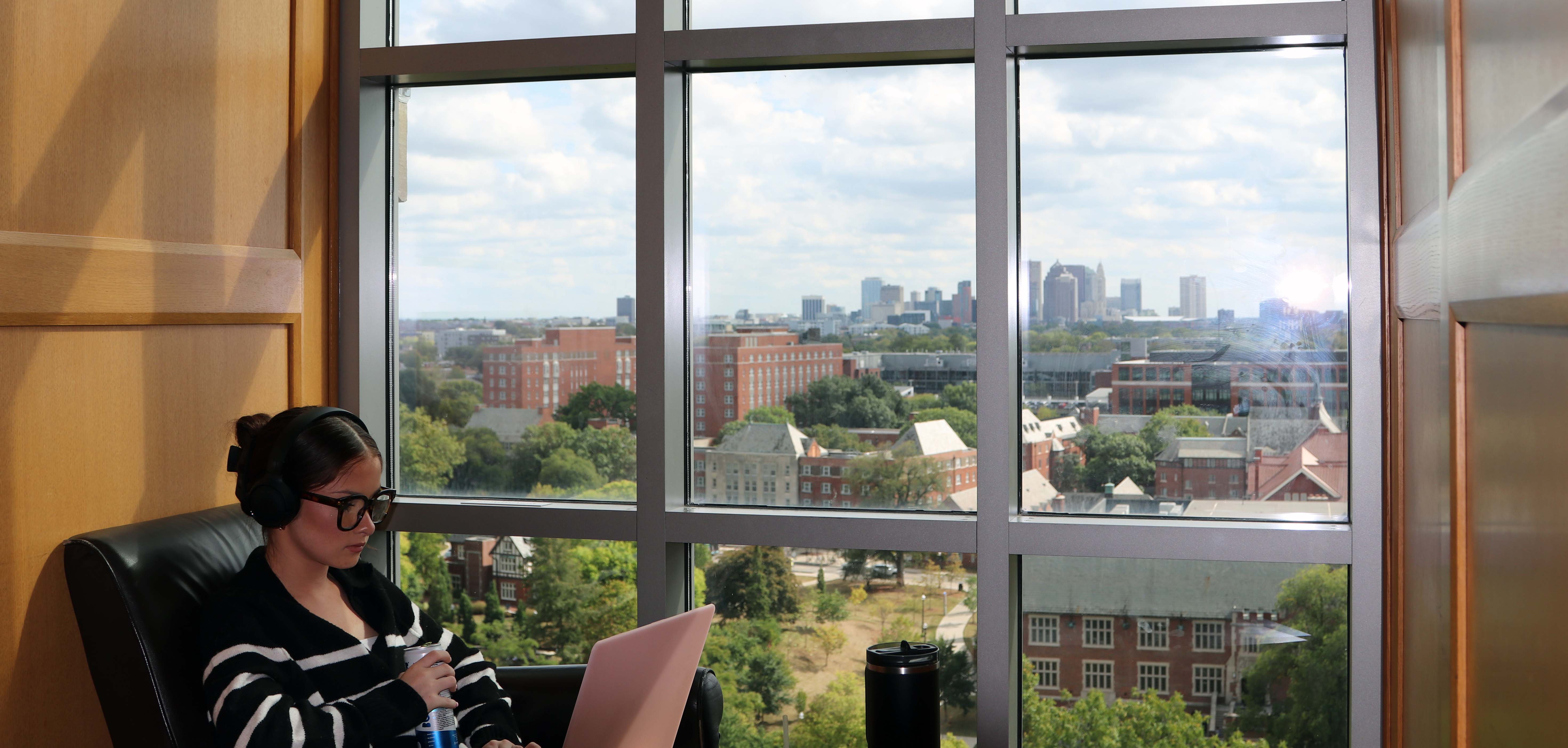 Student studying in the Ohio State Thompson Library overlooking downtown Columbus
