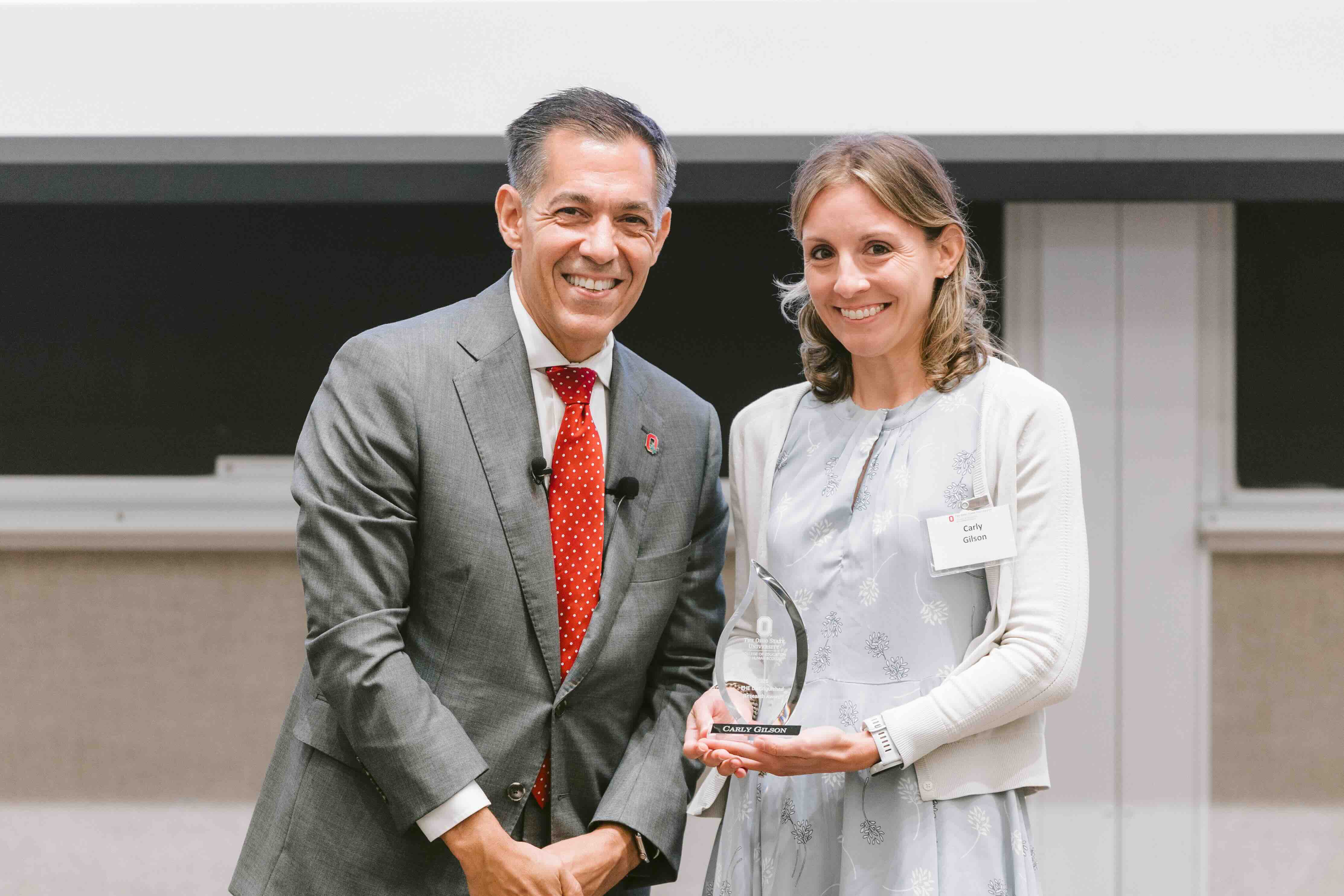 Carly Gilson receiving an award from Dean Erik Porfeli