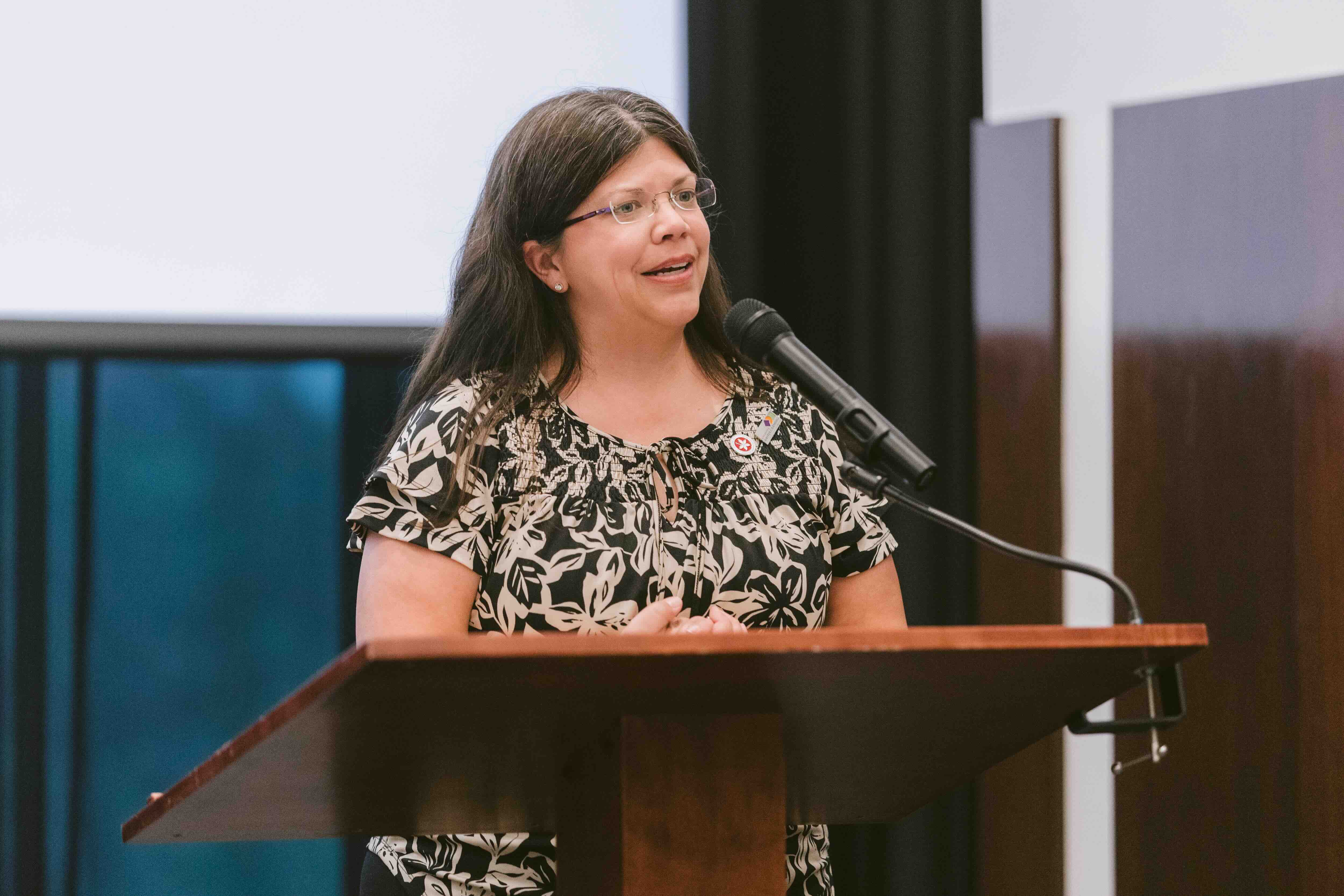 Gina Ginn speaking at a podium