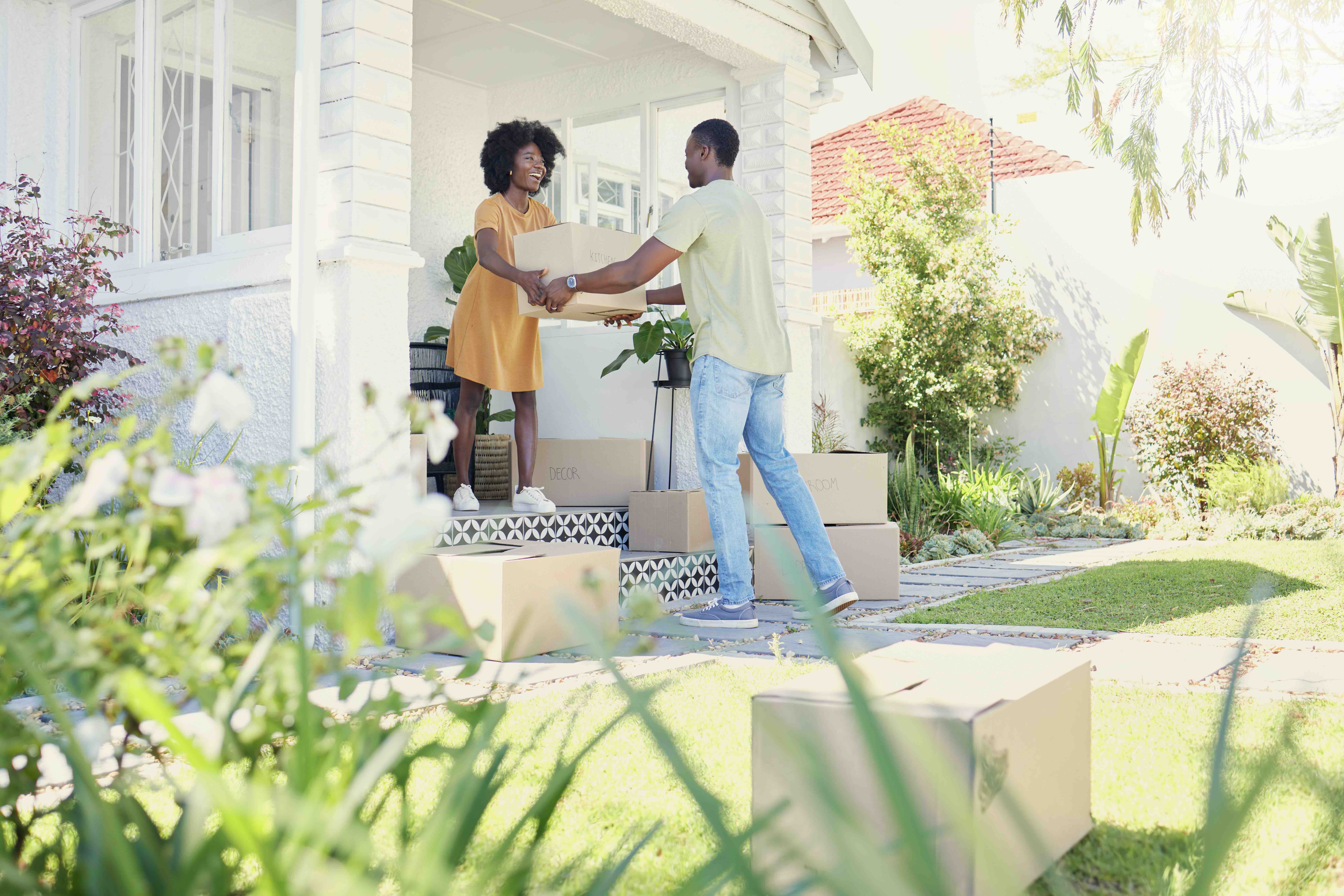 Couple moving boxes into a new house