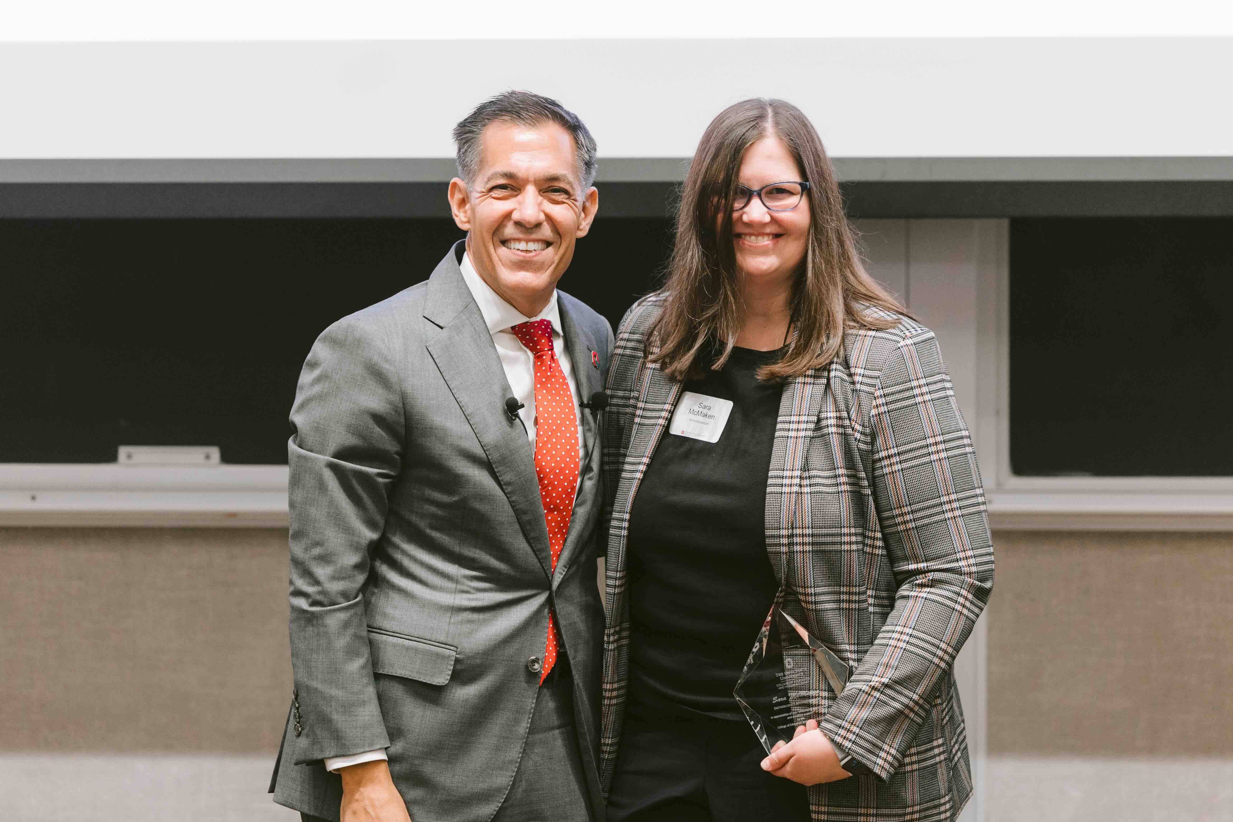Sara McMaken receives an award from Dean Erik Porfeli