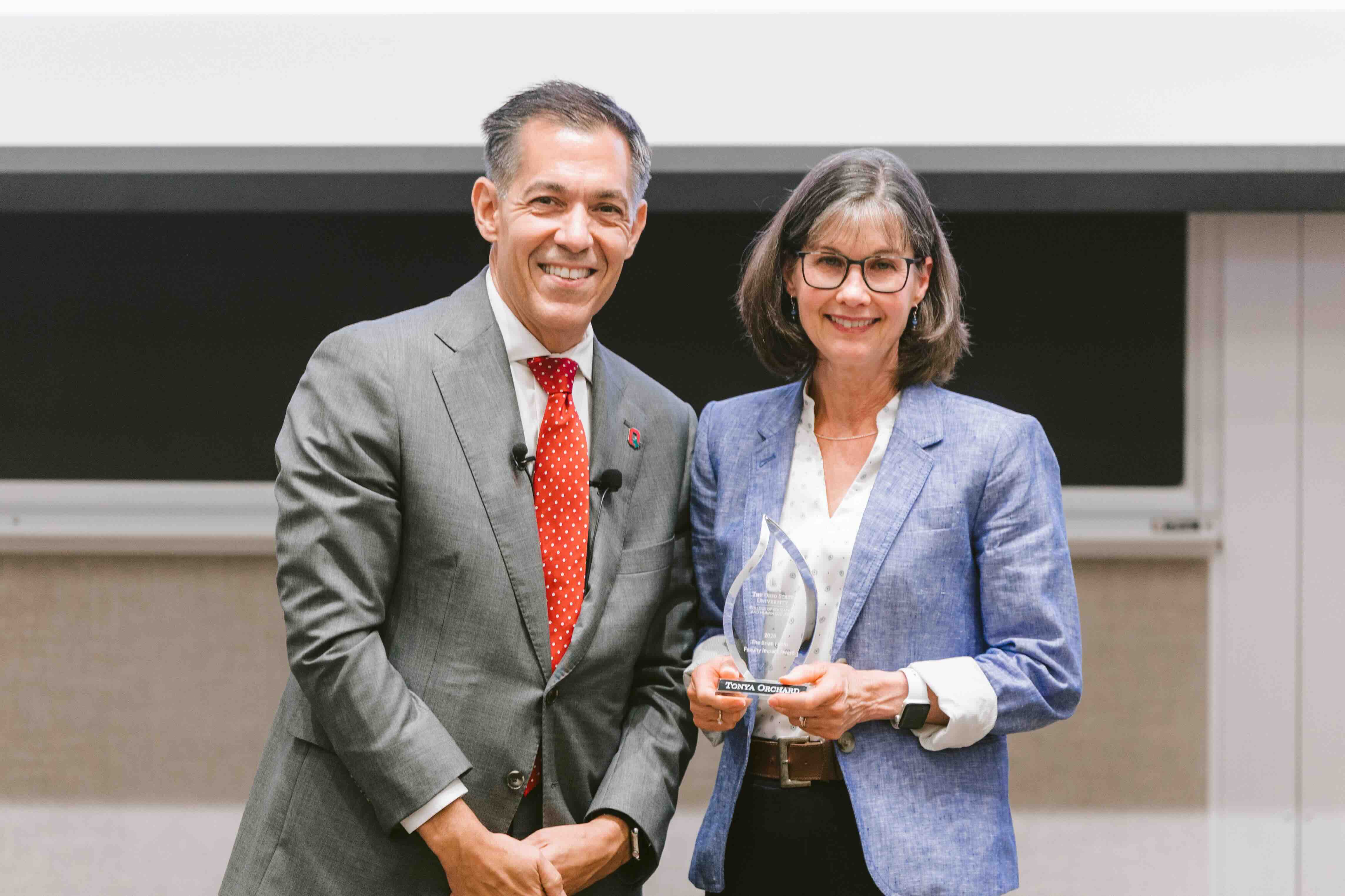 Tonya Orchard receives an award from Dean Erik Porfeli