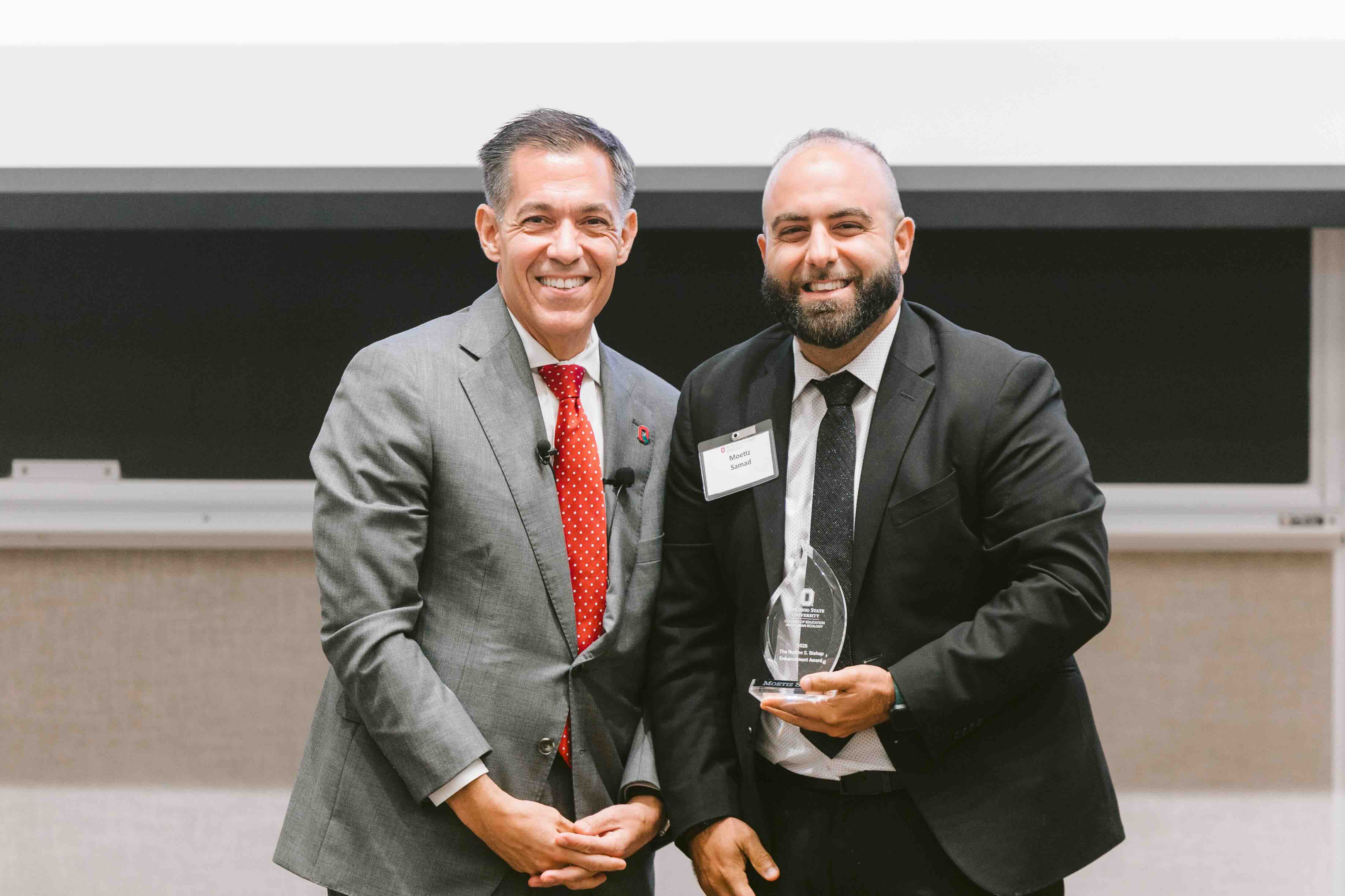 Moetiz Samad receives an award from Erik Porfeli