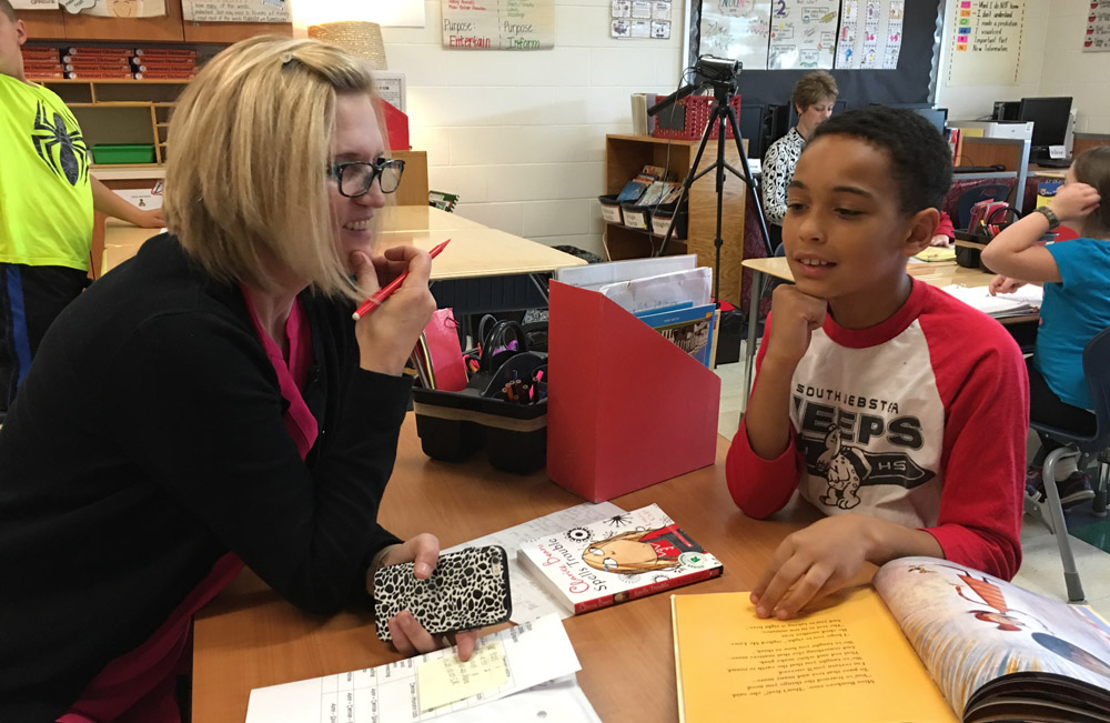 a teacher sitting at a table with a child
