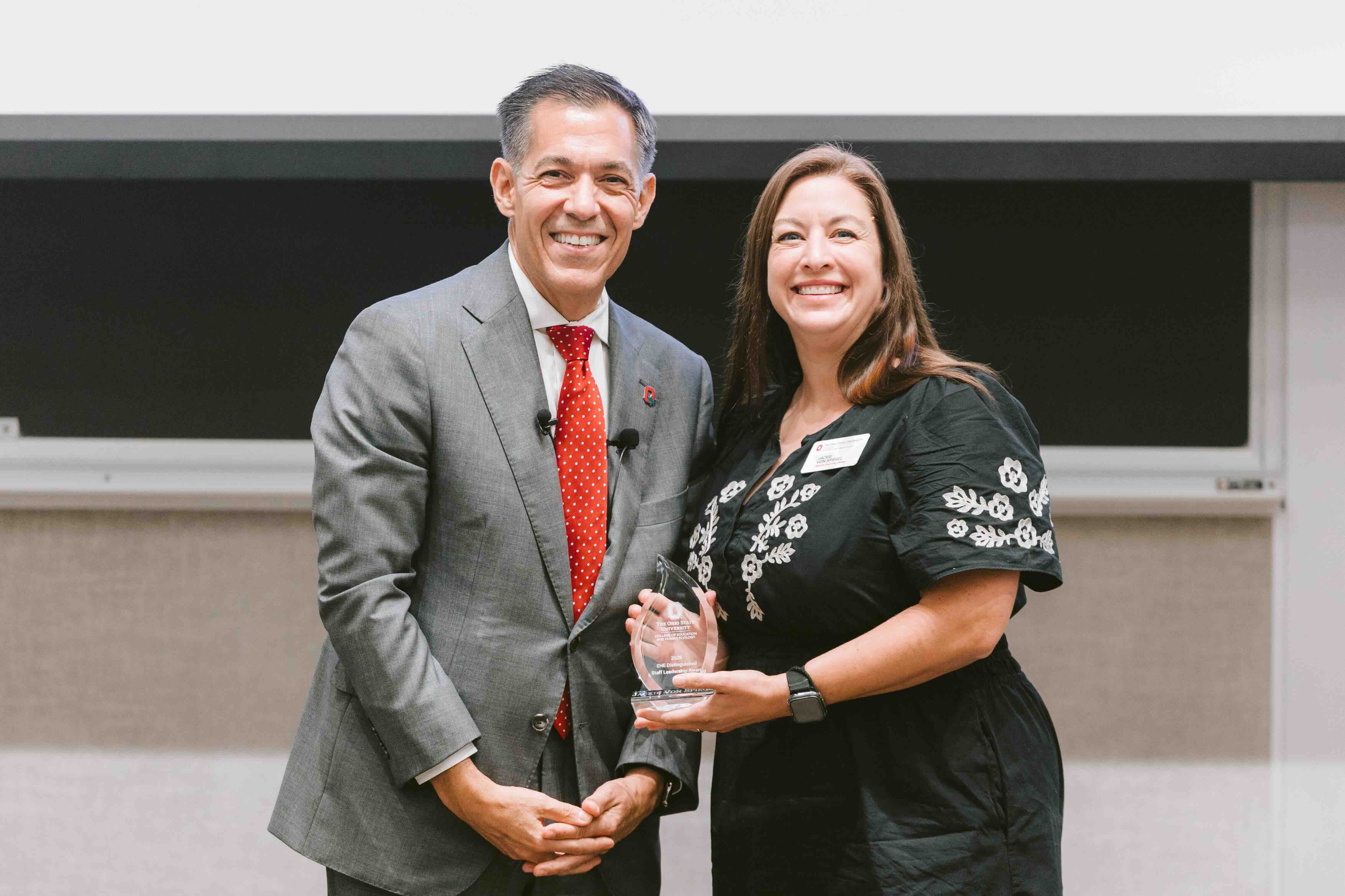 Jackie Von Spiegel receives an award from Dean Erik Porfeli
