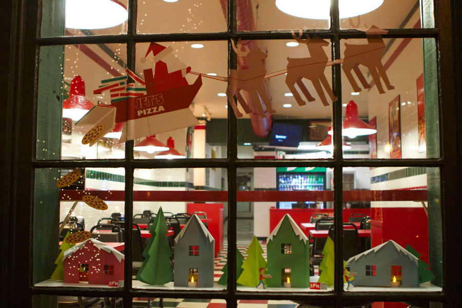 Christmas decorations displayed in a Jet's Pizza window