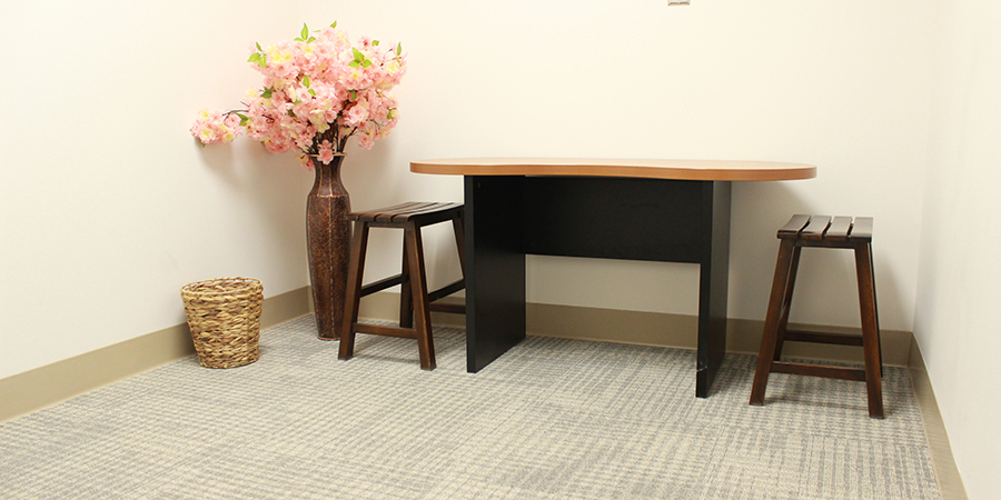 A meditation room with a table, chair and flowers in Campbell Hall.