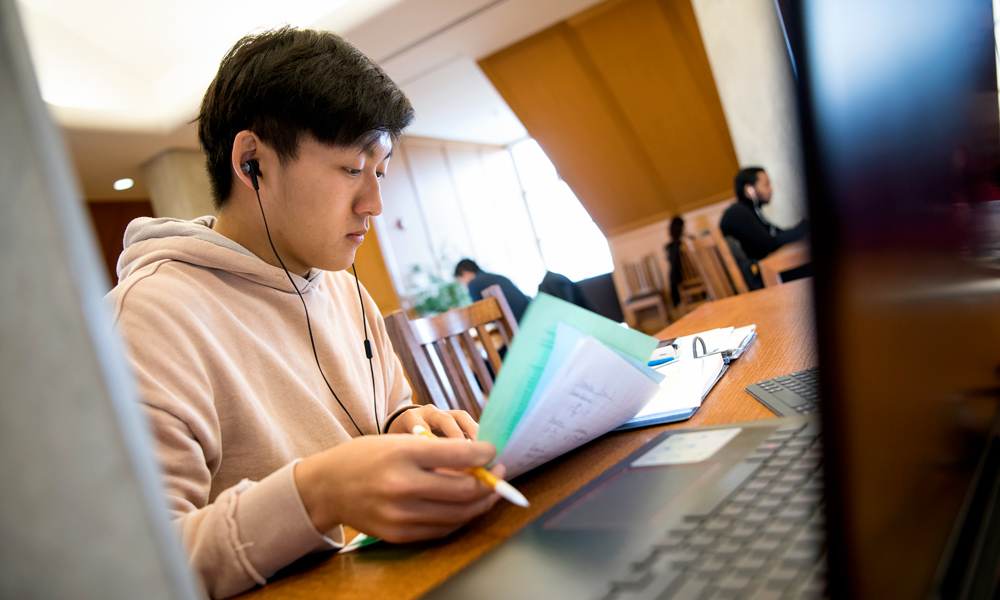 A student studies notes in a library