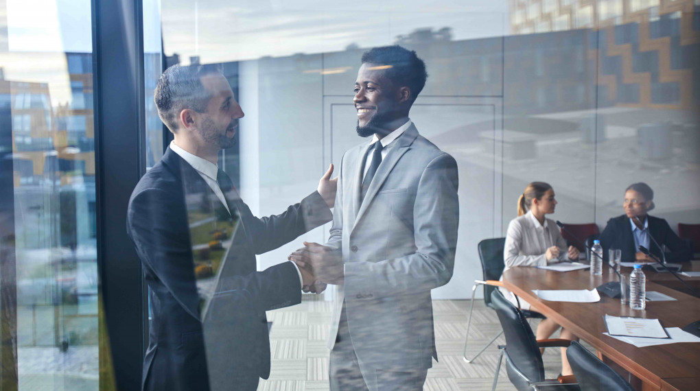 business men shaking hands in conference room