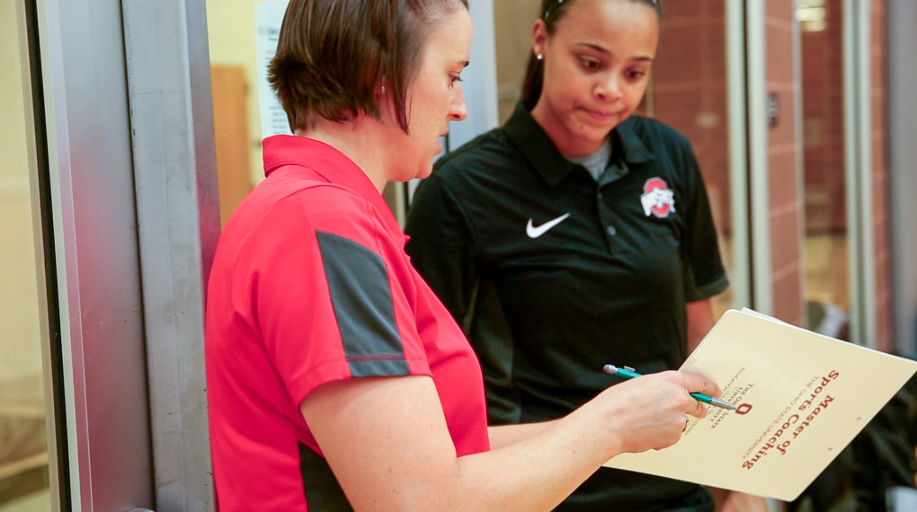 Ohio State physical education student discussing a chart with another student