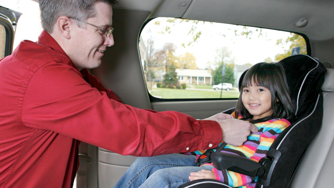 parent putting child in car seat
