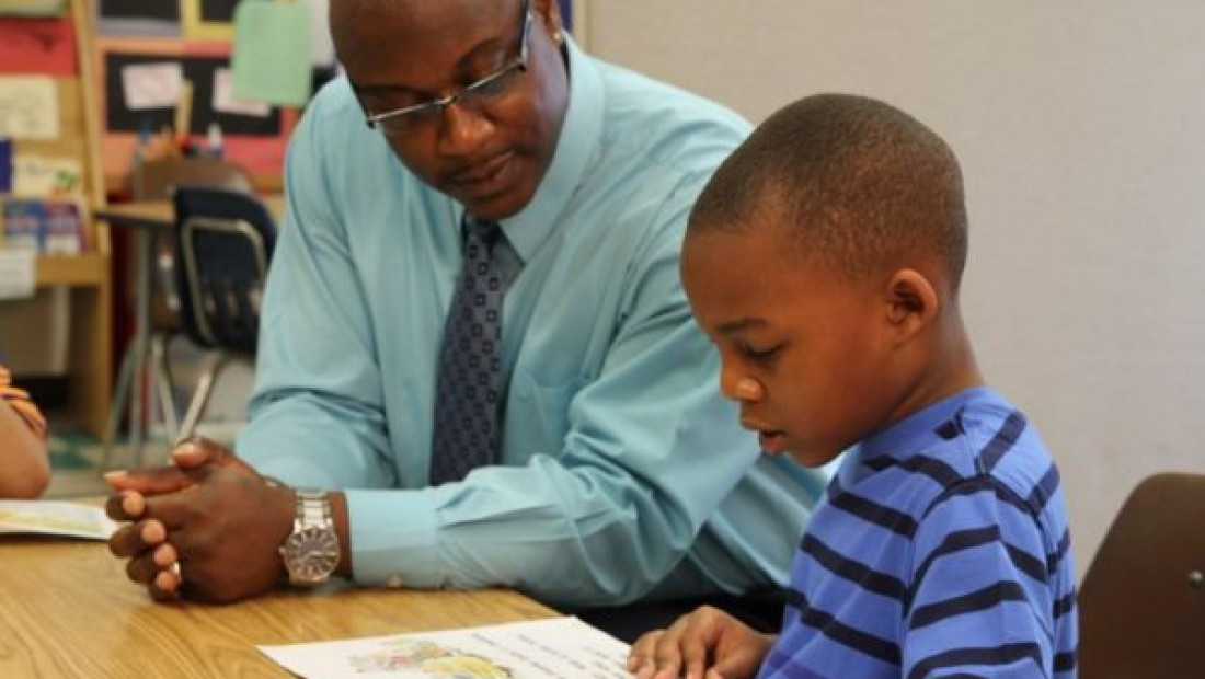 teacher helping student at desk