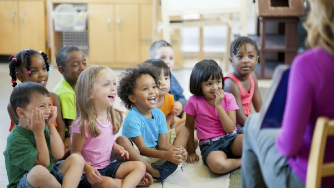 a group of children sitting on the floor in a classroom