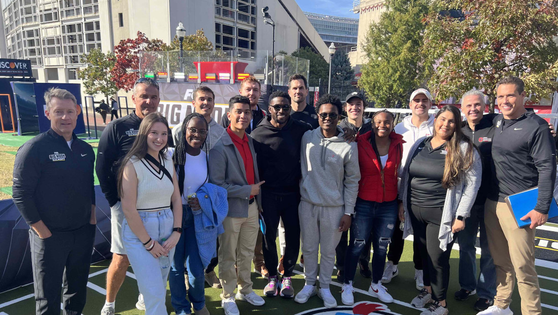 Ohio State Sport Management group posing together for a photo on a football field
