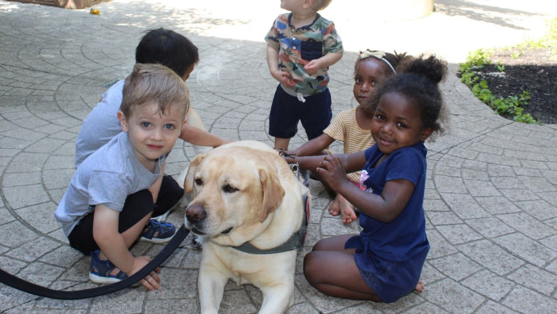 Dog being pet by young students during a Buckeye Paws event
