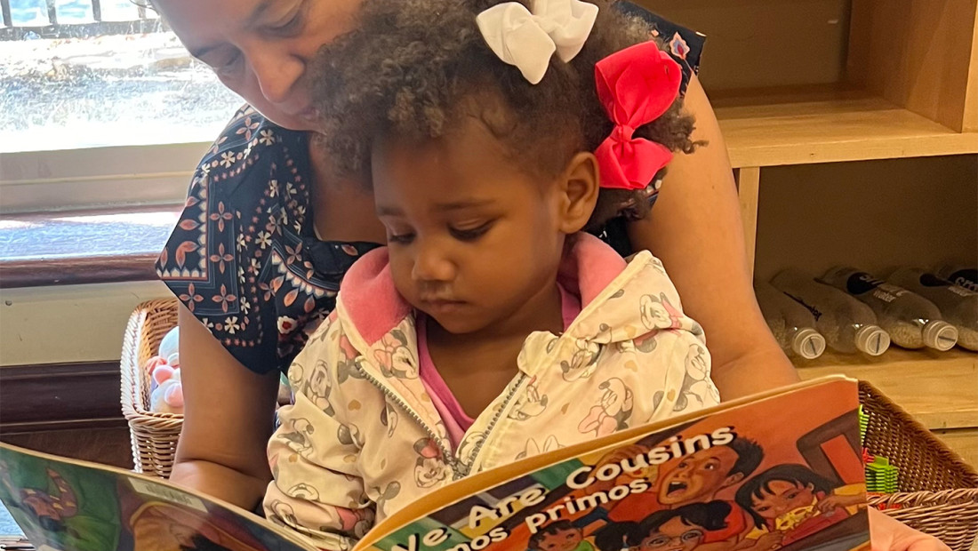 Teacher reading picture book to child