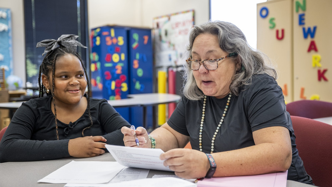 Teacher testing a with student for dyslexia in a classroom setting