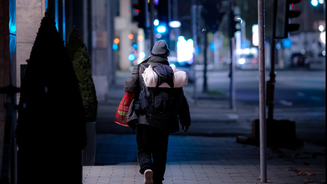 person walking in the city at night with bags