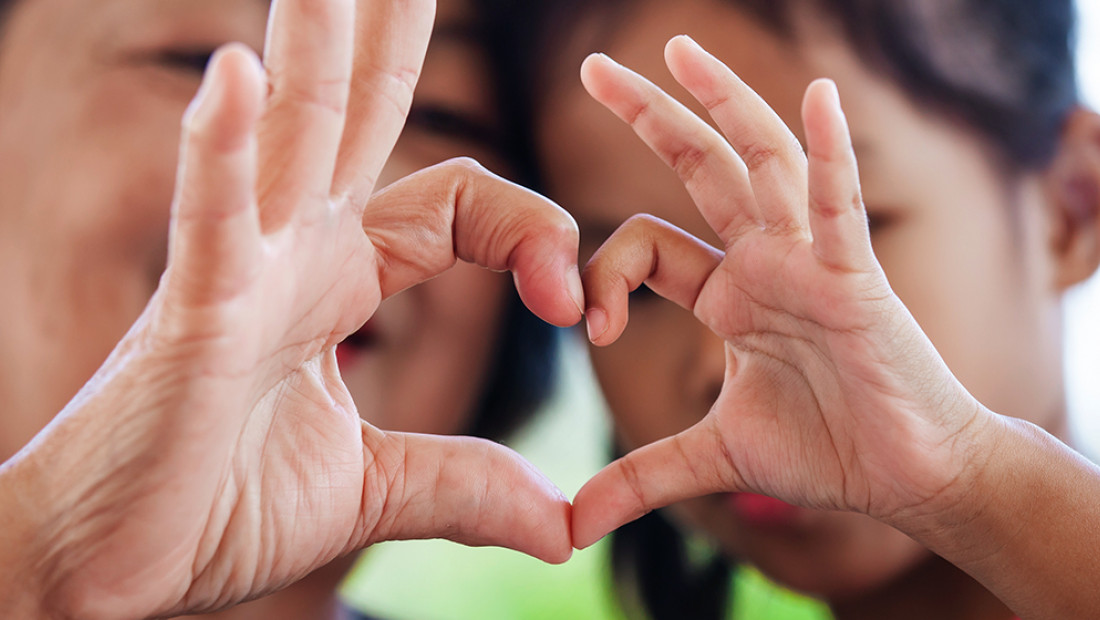 Children making a heart shape with their hands