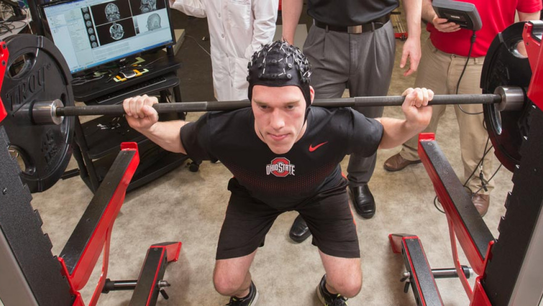 a man in a black shirt lifting a barbell