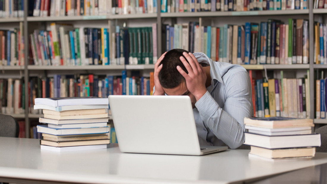 student with hands on head