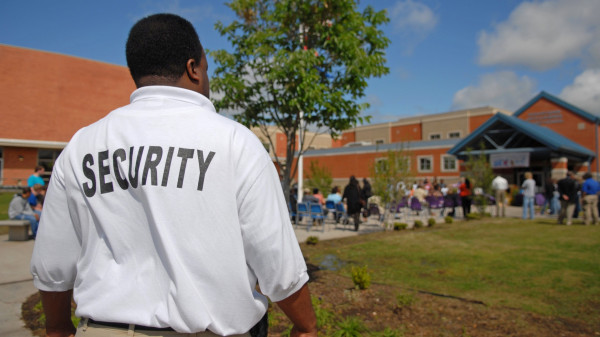 Security guard out front of a school building