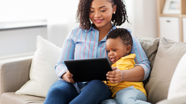 mother sitting with child looking at tablet