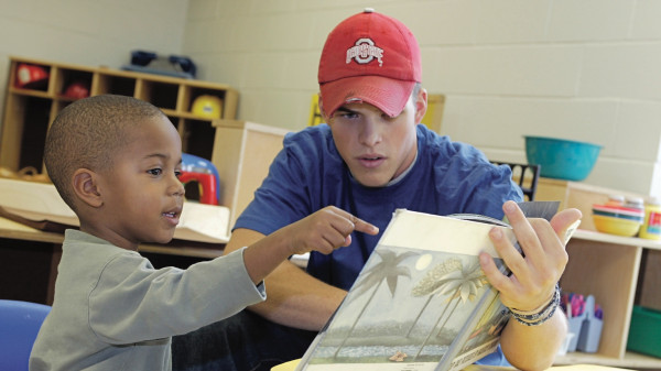 Ohio State student reading picture book to young student