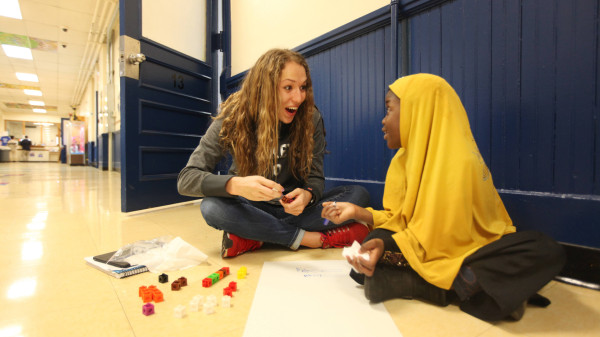 teacher and student sitting in school hallway