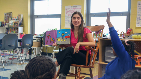 Zoe Weinland, an Ohio State alumna, reads to her class of young children in the classroom