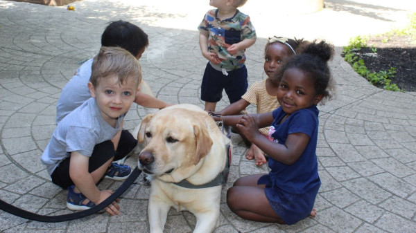 Dog being pet by young students during a Buckeye Paws event