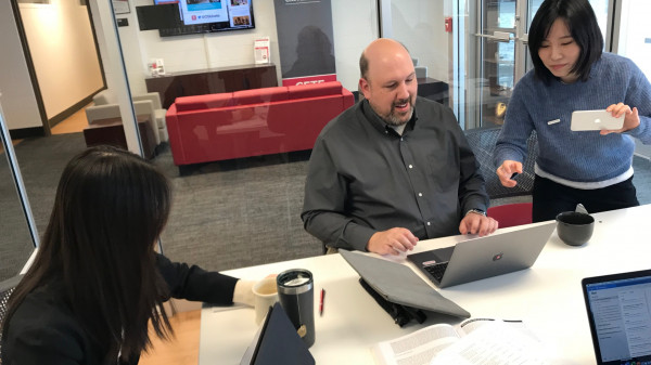 Ohio State office workers at a table with laptops