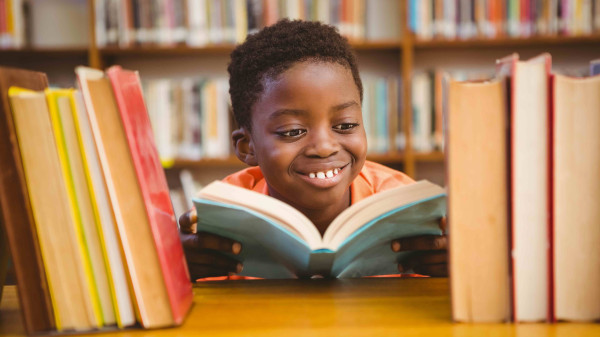 Child reading surrounded by books in a library
