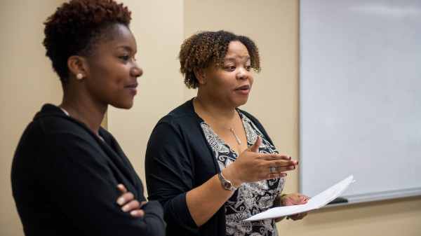 Teacher and university student at the front of the classroom