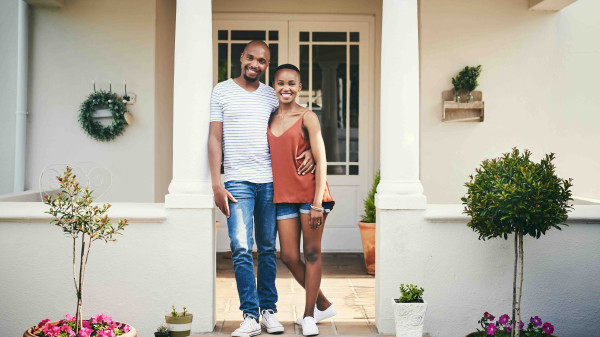 Couple standing on the porch of their home
