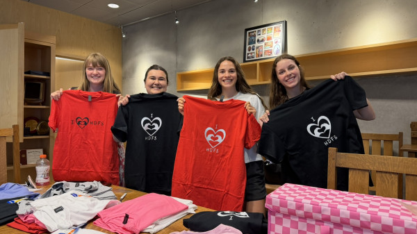 HDFS students holding up t-shirts that read "I heart HDFS"