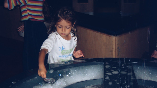 little girl playing with soap bubbles