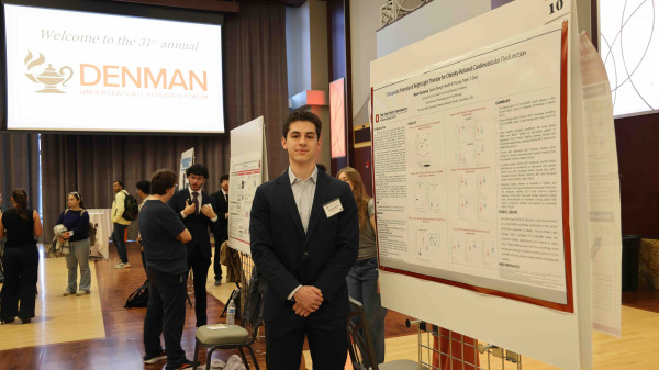Student standing next to poster presentation at a research forum
