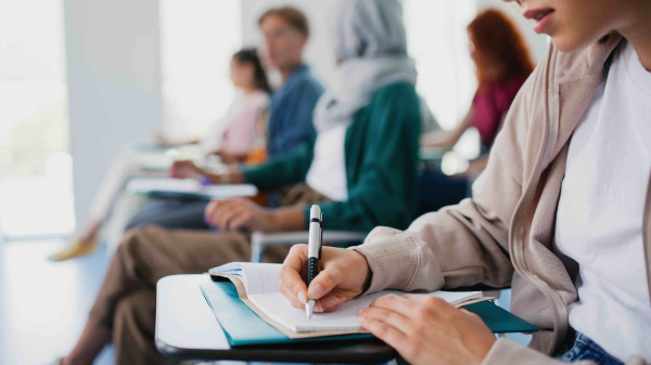 college students taking notes in class
